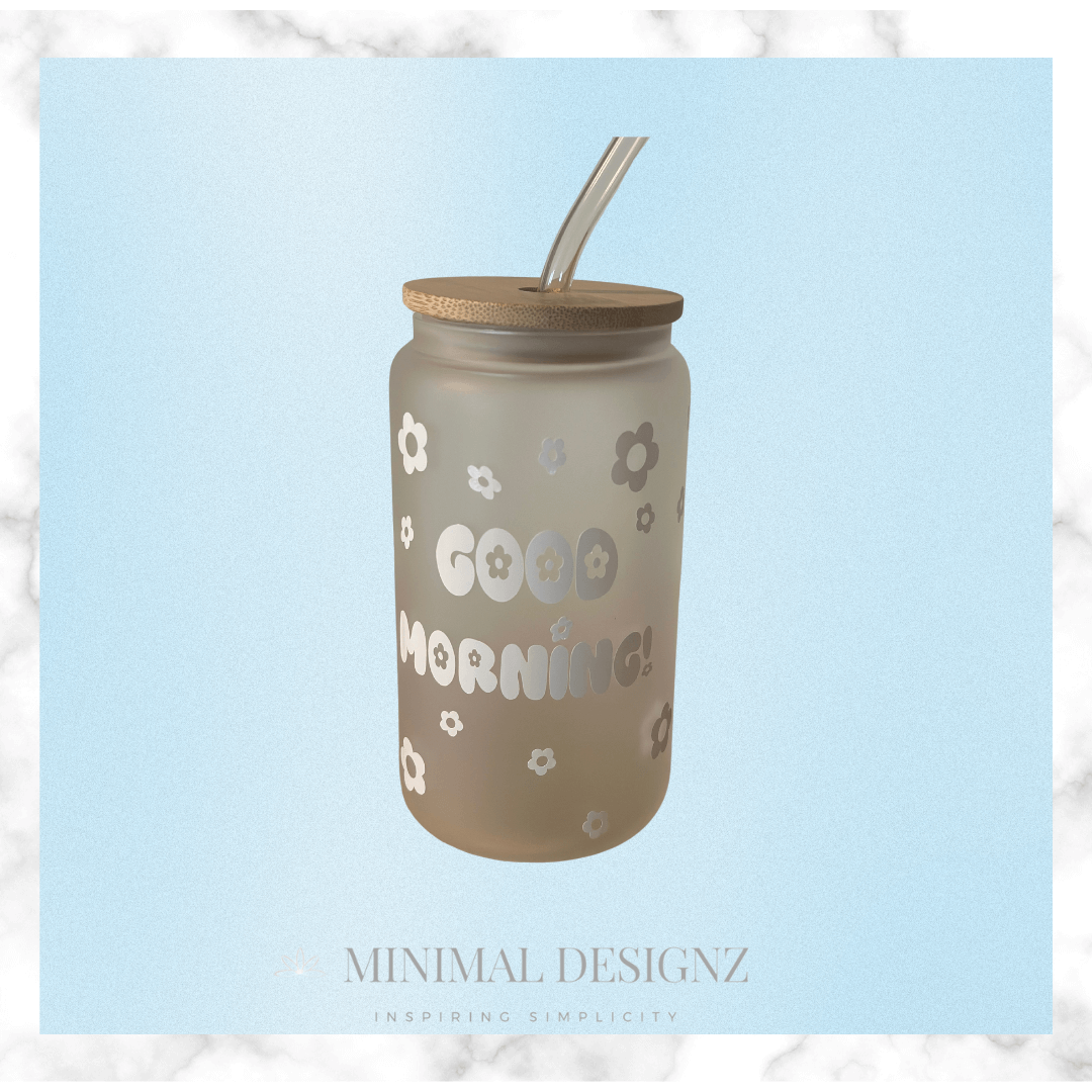 Clear glass iced coffee drinking glass with bamboo lid and glass drinking straw , frosted glass white vinyl decal design that says good morning with daisy flower outline Libby glass 
