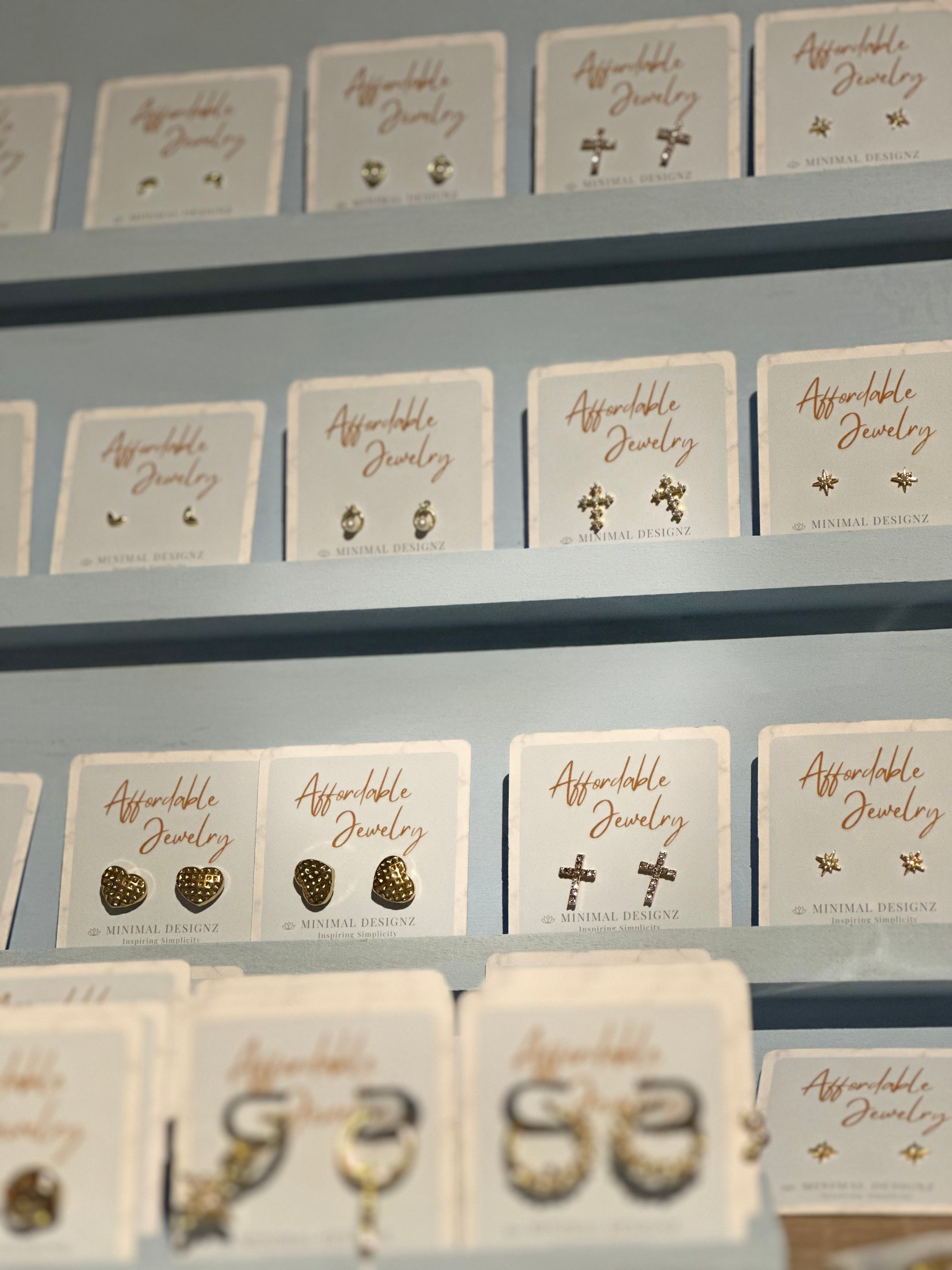 Affordable jewelry , stud earrings displayed vertically in blue packaging minimal designed jewelry 